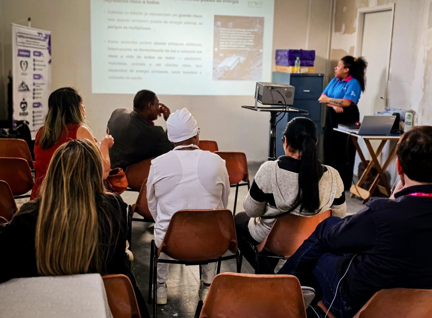 Turma acompanha uma aula de capacitação com projetor na sede do Instituto AMEAS.