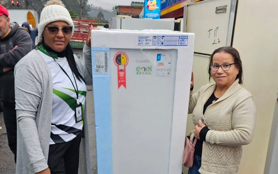 Voluntária do Instituto acompanha uma moradora na retirada de um refrigerador pelo programa habitacional Pode Entrar.