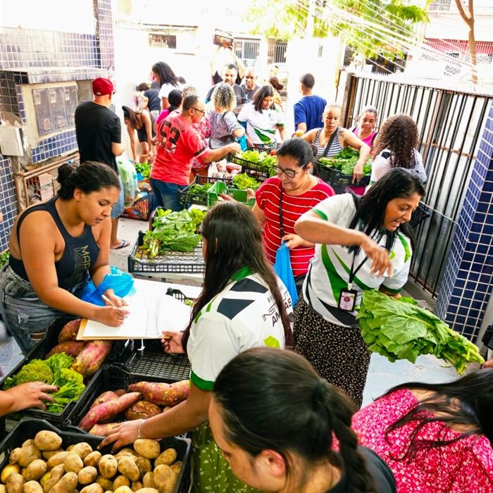 Moradores escolhem verduras, legumes e frutas durante uma distribuição de alimentos.
